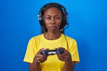 Poster - African american woman playing video games skeptic and nervous, frowning upset because of problem. negative person.