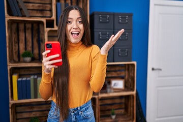 Sticker - Young brunette woman using smartphone celebrating victory with happy smile and winner expression with raised hands