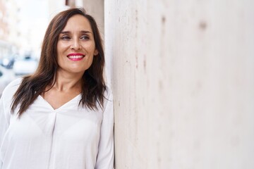 Wall Mural - Young beautiful hispanic woman smiling confident looking to the side at street