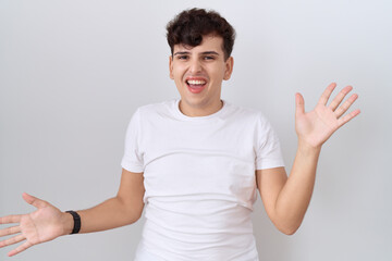 Wall Mural - Young non binary man wearing casual white t shirt celebrating crazy and amazed for success with arms raised and open eyes screaming excited. winner concept