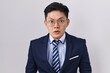 Young asian man wearing business suit and tie afraid and shocked with surprise and amazed expression, fear and excited face.