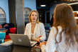 © SlavaStock - Employees cooperate for teamwork at shared modern workspace. Female managers talk during break at shared workspace in business company