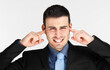 © Minerva Studio - Businessman blocking noise with fingers in ears