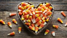 Colorful Halloween Candy Corns In Heart Shape On Wooden Background