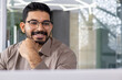 © Liubomir - Businessman close up inside office at workplace, man in glasses and shirt smiling reading email using laptop, employee satisfied with financial report results, dreamy and happy.