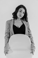 Wall Mural - Beautiful young girl in black trousers and a blue jacket on a white background. Portrait of a beautiful young woman