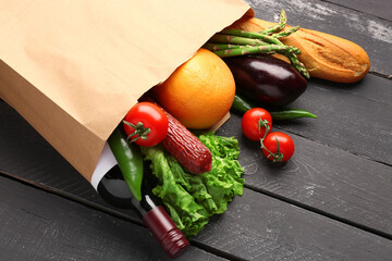 Sticker - Paper bag with vegetables, sausage and wine bottle on black wooden background