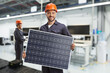 © Ljupco Smokovski - Worker in a uniform holding a solar panel in a factory