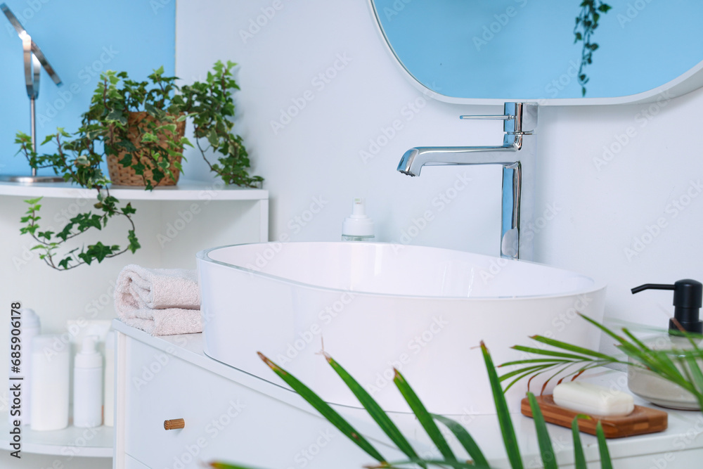 Sink with bath accessories on drawers in restroom