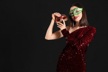 Sticker - Beautiful young woman with carnival masks on black background