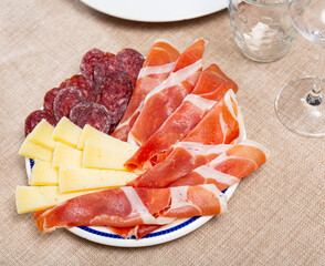 Canvas Print - Service plate containing sliced botifarra, ham and cheese with necessary table laying
