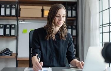 Accountant woman using laptop computer with  and working at desk in office,  Business statistics and analytic research concept.