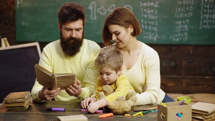 Fototapete - Cute clever boy study. Parents teaching children. Family in early development concept. Father mother and child son painting together at home.
