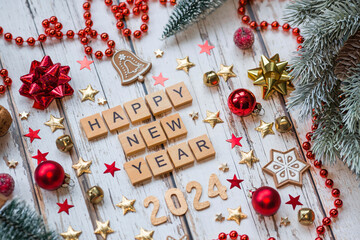 Wall Mural - A postcard or banner.A symbol from the number 2024 with red Christmas tree toys, stars, sequins and a beautiful bokeh on a white wooden background. Happy New Year 2024.The concept of the celebration.