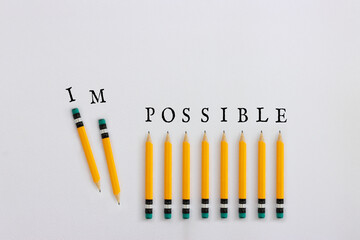 Poster - Pencils with the text impossible, stopping the domino effect. success and challenge concept