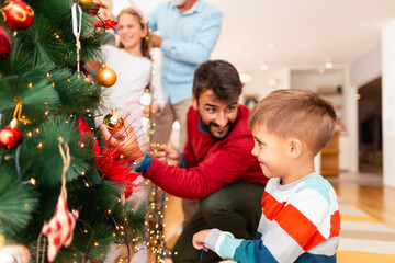 Wall Mural - Happy family decorating Christmas tree