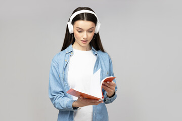 Wall Mural - Attractive young woman in headphones and notebooks in hands