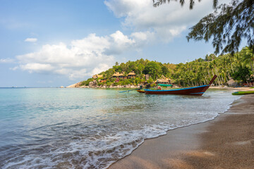 Wall Mural - Boat on empty calm sandy tropical Sairee beach in the morning on Koh Tao island in Thailand. Picturesque peaceful calm shore with copy space