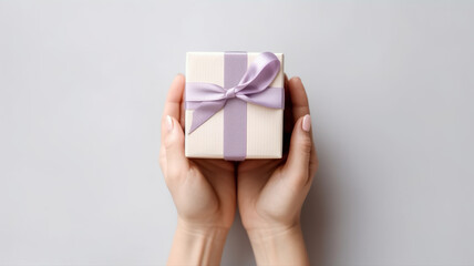 Photo female hands hold a small gift box on a white table background top view