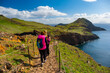 Tourists on hiking path on Ponta de Sao Lourenco Madeira Portugal. Green landscape cliffs and Atlantic Ocean. Ative day, travel background