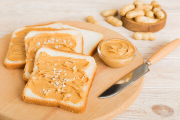 Wall Mural - Peanut butter sandwiches or toasts on light table background.Breakfast. Vegetarian food. American cuisine top view vith copy space