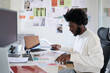 © Just images - Busy black man working at the desk of his business office