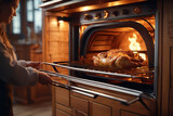 Fototapeta Sawanna - Young woman opens the oven to check roasting chicken.