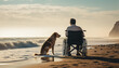 Man on wheelchair wheelchair on the beach with dog