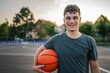 © Miljan Živković - One caucasian teenager stand on basketball court with ball