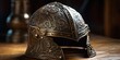 A medieval knight's helmet with intricate engravings, placed on a wooden table