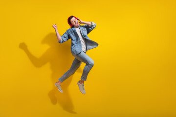 Canvas Print - Full length photo of impressed lucky guy wear denim jacket jumping enjoying songs walking empty space isolated yellow color background