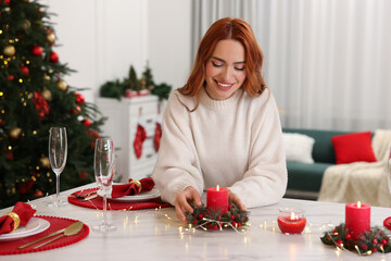 Sticker - Beautiful young woman setting table in room decorated for Christmas