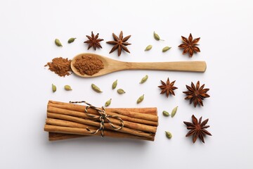 Wall Mural - Cinnamon sticks, star anise and cardamom pods on white background, flat lay