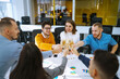 © maxbelchenko - Business people celebrate with glasses of champagne in the office at a corporate event. A group of young people are having fun in the office. Holidays, business concept.
