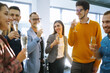 © maxbelchenko - Business people celebrate with glasses of champagne in the office at a corporate event. A group of young people are having fun in the office. Holidays, business concept.