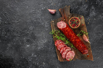 Wall Mural - dry sausage sliced salami on a wooden board. banner, menu, recipe place for text, top view