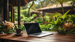 Laptop on wooden table top, blurry background of tropical garden, clam quite setting