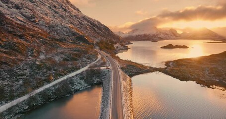 Wall Mural - aerial view of road, sea and snowy mountains at sunset in winter. lofoten islands, norway. top drone