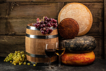 Wall Mural - Glass of wine, cheeses and grapes on a wooden background, A head of hard cheese