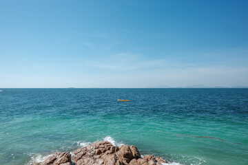 Outdoor scenery view over sea waves with clear water crushing over the rocks during beautiful sunny day. 