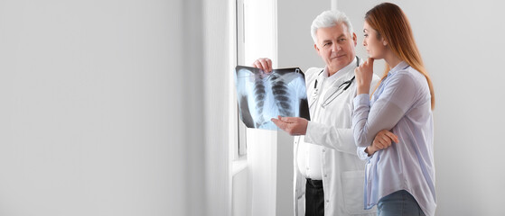 Wall Mural - Senior doctor with x-ray image of lungs and female patient in clinic. Banner for design