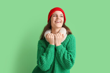 Canvas Print - Happy young woman in winter clothes on green background