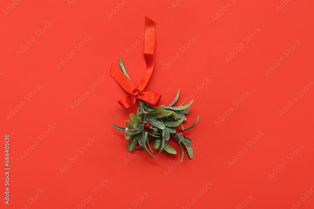 Mistletoe branch with bow on red background
