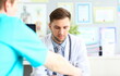 © H_Ko - Doctor talks and listens to patient in clinic. Male conversation with urologist concept