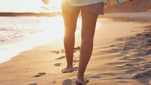 Close Up And Portrait Of Legs Of One Young Afroamerican Woman Walking And Running Having Fun Enjoying On The Sand Of The Beach With The Sunset At The Background
