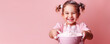 © IndigoElf - Сute little girl smile and make baked goods in a pink minimalist kitchen. Child soiled in flour, learning to cook, fun home activity, copy space for text.