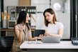 © Nuttapong punna - Two Asian businesswoman discuss investment project working and planning strategy with tablet laptop computer