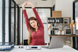 woman is doing a stretchy posture due to sitting in the office for too long, office syndrome concept.