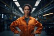 © Ева Поликарпова - A woman wearing an orange jacket stands in a warehouse. This image can be used to represent industrial work, storage, or a professional setting.