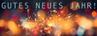 Gutes neues Jahr, Neujahr Silvester Party Grußkarte mit deutschem Text - Nahaufnahme von funkelnden Wunderkerzen mit bunten Bokeh Lichtern im Hintergrund